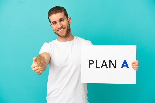 Homem loiro bonito sobre um fundo azul isolado segurando um cartaz com a mensagem PLANO A fazendo um acordo