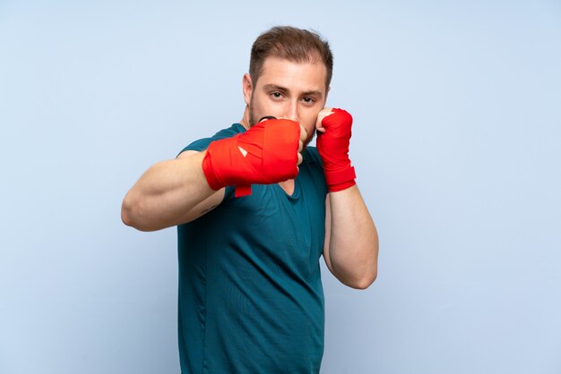 Homem loiro esporte parede azul em bandagens de boxe