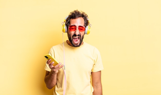 Homem louco expressivo gritando agressivamente, parecendo muito zangado com fones de ouvido