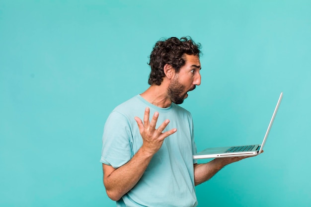 Homem louco latino-americano adulto jovem com um laptop