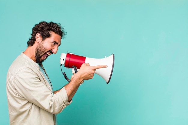 Homem louco latino-americano adulto jovem com um megafone