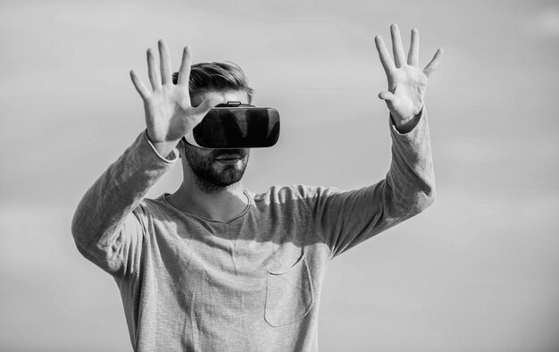 Homem macho usa óculos VR sem fio Desfrutando de uma nova experiência Futuro digital e inovação cara óculos de realidade virtual homem sexy fundo do céu óculos vr realidade masculina parecendo tão moderno