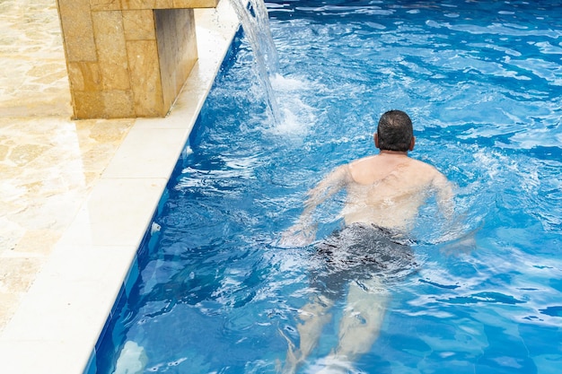 Homem maduro nadando na piscina