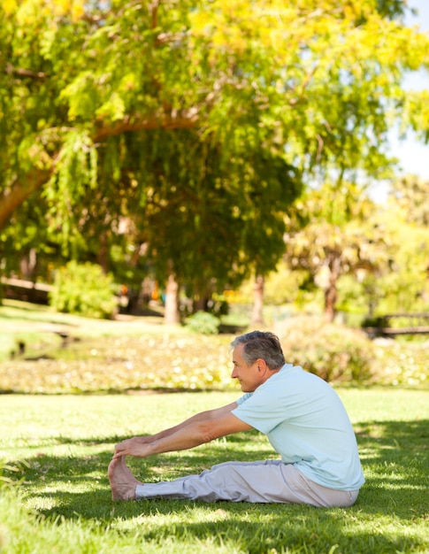 Homem maduro que faz seus streches no parque