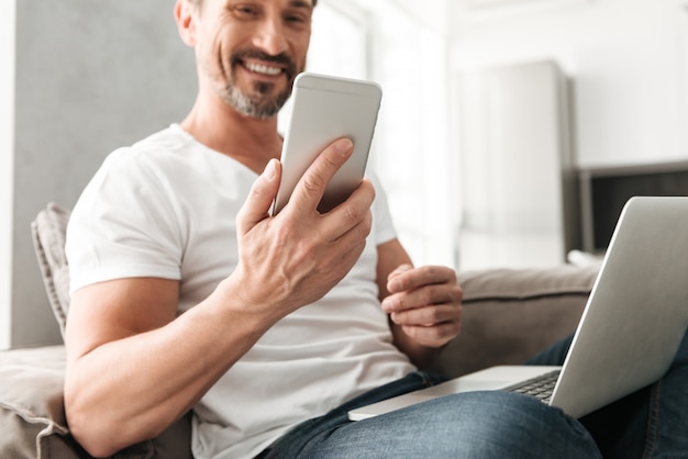 Homem maduro sorridente usando telefone celular