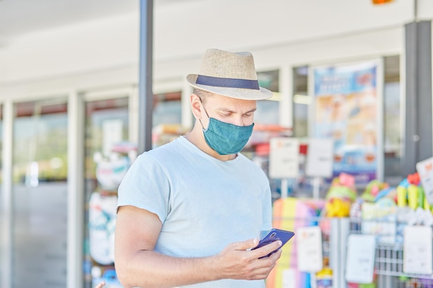 Homem mascarado com chapéu de verão com um telefone na rua Restrições de quarentena Empresário Foto de alta qualidade