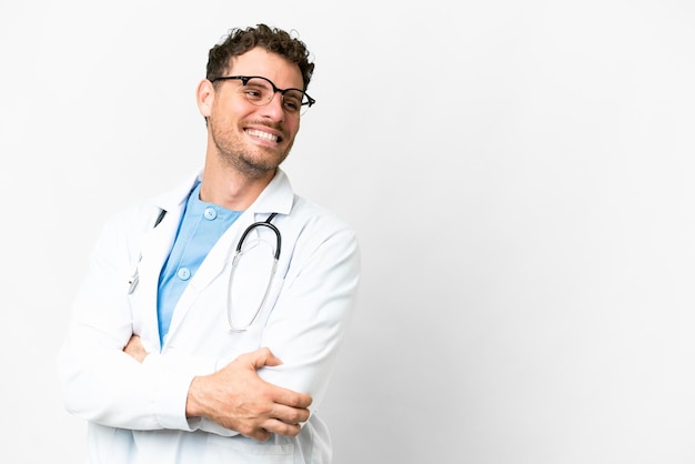 Homem médico brasileiro sobre fundo branco isolado com os braços cruzados e feliz