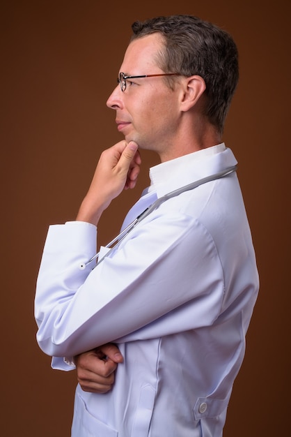 homem médico contra parede marrom