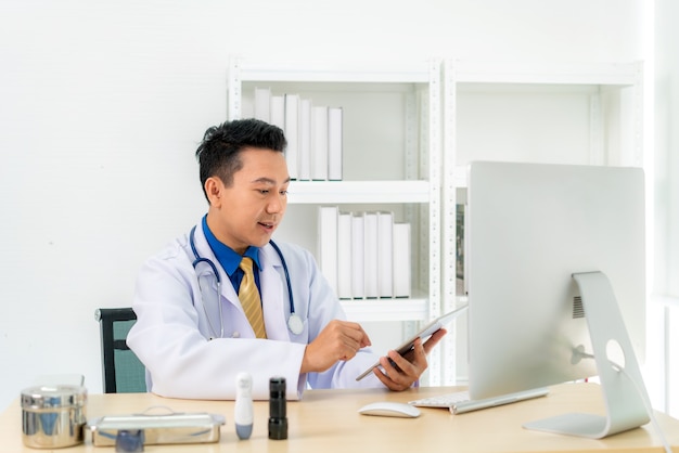 Homem médico usa jaleco branco e fone de ouvido falando em videoconferência no laptop