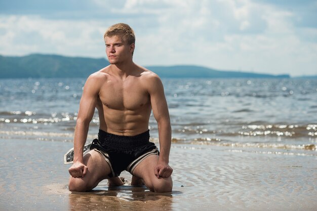 Homem medita na praia depois de um treino