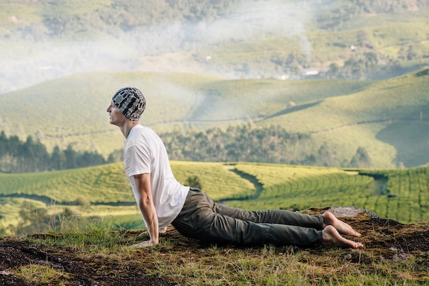 Homem meditando na natureza pela manhã. Fazendo ioga ao ar livre.