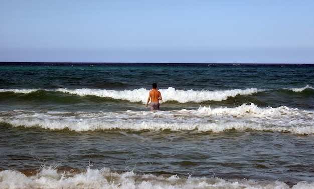 Homem mergulha nas ondas do mar