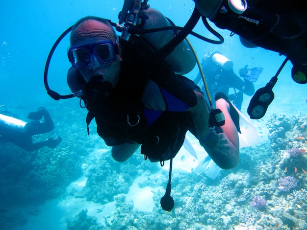 Homem mergulhador e lindo recife de coral colorido debaixo d'água