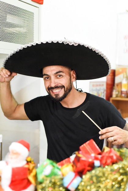 Homem mexicano em sombrero segurando bigode em uma vara e sorri para a câmera