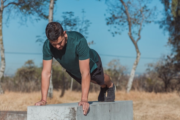 Homem mexicano fazendo flexões do lado de fora