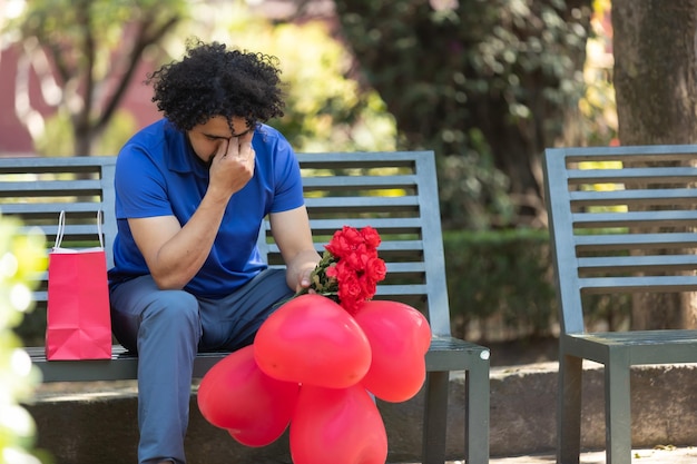 Homem mexicano sentado no banco do parque chorando no dia dos namorados encontro ruim
