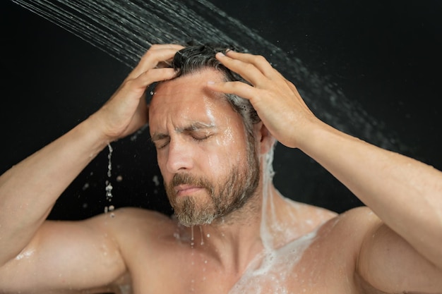 Homem milenar lavando o cabelo no banho homem tomando banho cabeça de chuveiro na banheira rosto em espuma no chuveiro
