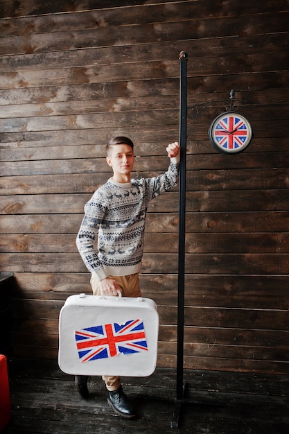 Homem moda jovem com uma mala com a bandeira britânica