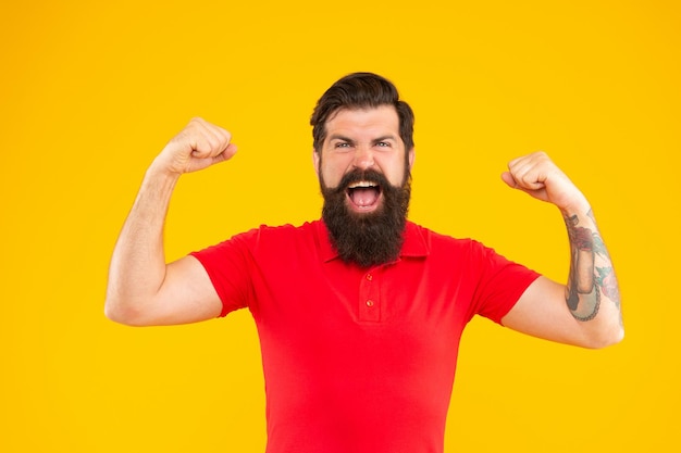 Homem moderno de sucesso com barba em fundo amarelo, sucesso.