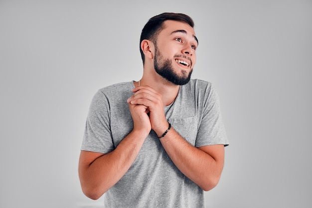 Homem moderno feliz de bom coração sorri alegremente de prazer, dá as mãos juntas, expressa emoções agradáveis, simpatia e grande amor. Romântico alegre faz pedido de casamento para namorada