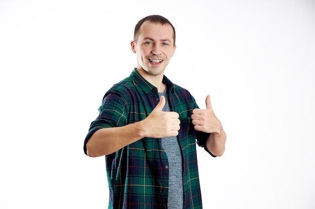 Foto homem mostra um gesto de polegar para cima, alegria e um sorriso, recomenda. isole em um fundo branco