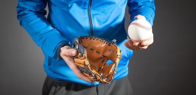 Homem mostrando bola de beisebol e luva de couro