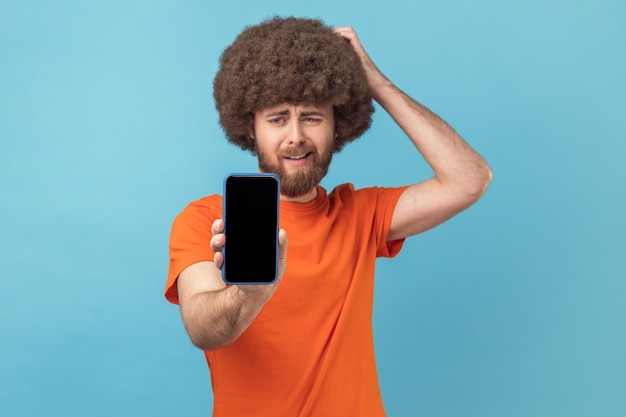 Homem mostrando o celular com tela vazia apresentando área para propaganda