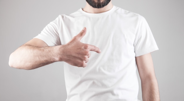 Homem mostrando sua camiseta branca.