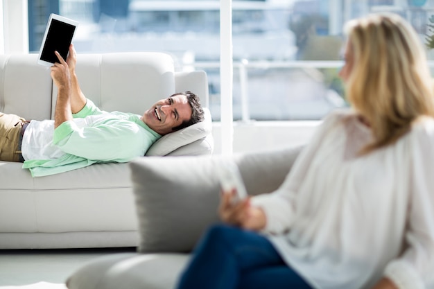 Homem mostrando tablet digital para mulher