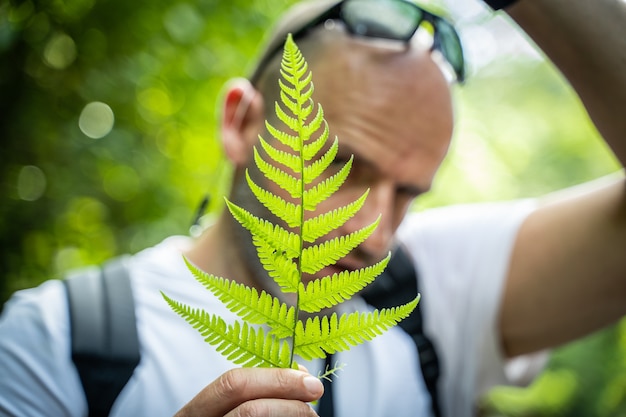 Foto homem mostrando uma folha na selva. costa rica