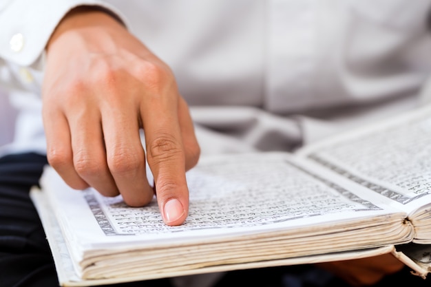 Homem muçulmano asiático estudando o Alcorão ou o Alcorão