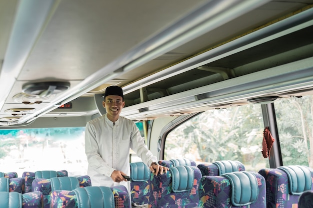 Homem muçulmano asiático feliz fazendo eid mubarak viajando de volta para sua cidade natal em um ônibus