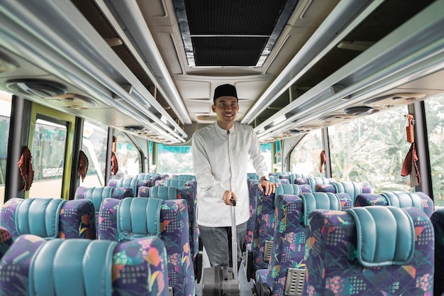 Homem muçulmano asiático feliz fazendo eid mubarak viajando de volta para sua cidade natal em um ônibus
