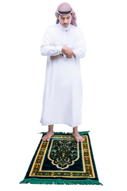 Homem muçulmano com keffiyeh com agal em posição de oração salat no tapete de oração