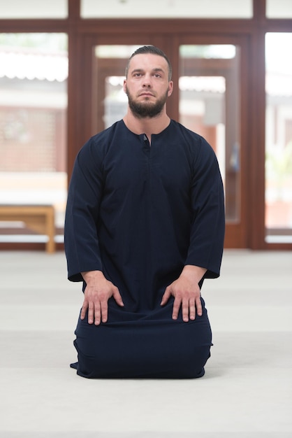 Homem muçulmano humilde está rezando na mesquita