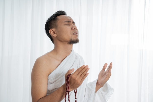 Foto homem muçulmano rezando em roupas brancas tradicionais