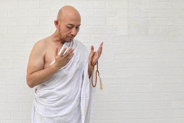 Homem muçulmano rezando usando ihram isolado sobre fundo branco
