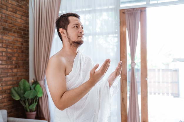 Homem muçulmano rezando vestindo roupas de ihram
