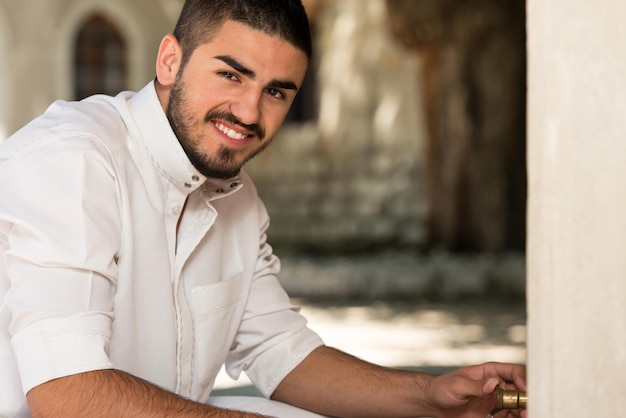 Foto homem muçulmano se preparando para fazer a ablução na mesquita