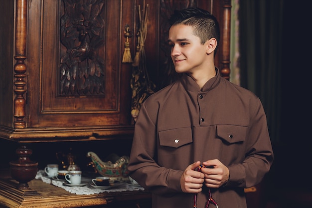 Homem muçulmano sorridente com boné e vestido tradicional na mesquita