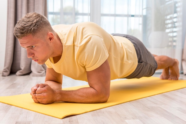 Foto homem muito apto a fazer exercício em casa