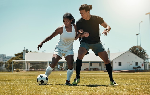 Homem mulher e jogando futebol no campo do estádio gramado e ambiente  natural em jogo de competição e desafio amigos de fitness esportistas e  jogadores de futebol em treinamento de bola de