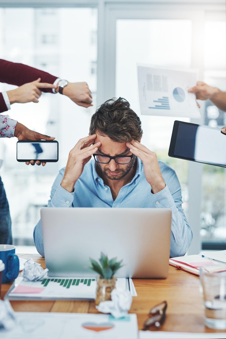 Foto homem multitasking e dor de cabeça na mesa com prazos estresse e esgotamento no laptop no escritório empresário sobrecarregado e tecnologia no local de trabalho com ansiedade tensão e depressão no computador