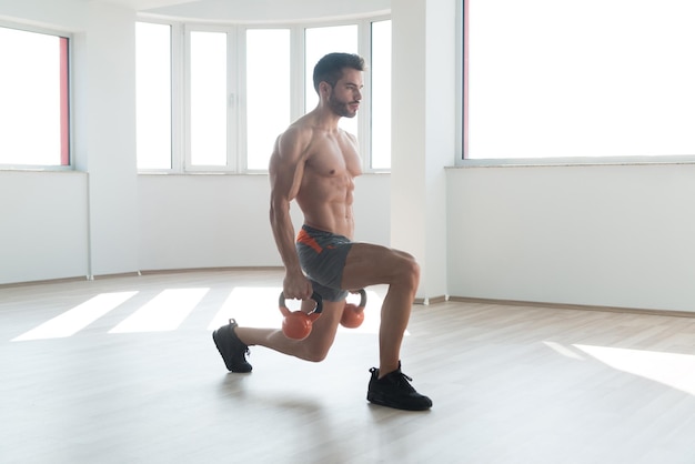 Homem muscular exercitando com kettlebell