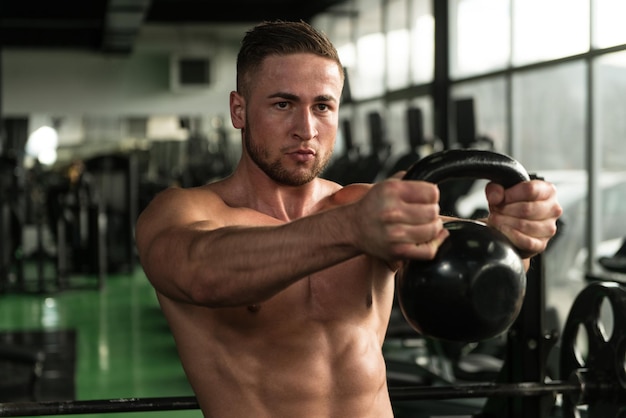 Homem muscular exercitando com kettlebell