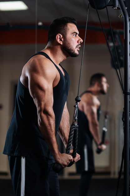 Foto homem musculoso durante um treino no ginásio treina o tríceps