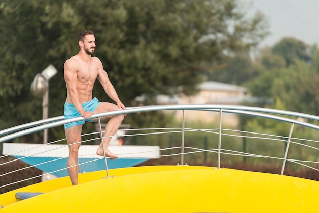 Homem musculoso em cueca descansando na piscina