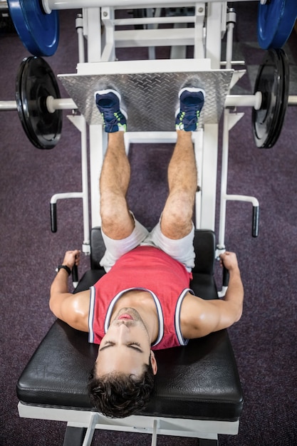 Foto homem musculoso fazendo exercício para as pernas no ginásio