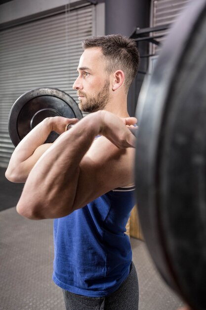 Homem musculoso, levantando a barra no ginásio crossfit