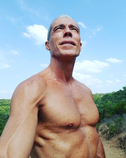 Foto homem musculoso sem camisa de pé contra o céu